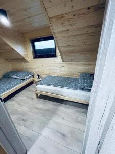 詹塔尔Luksusowe Domki Kalimera的配有窗户的小木屋内的两张床