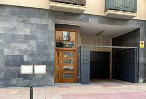 萨拉戈萨Suite Anna的一座带棕色门和阳台的建筑