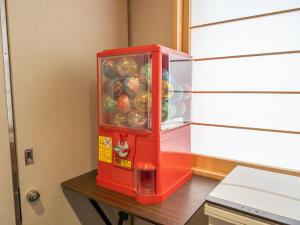 大阪Shinsaibashi ARTY Inn的红色冰箱坐在桌子上