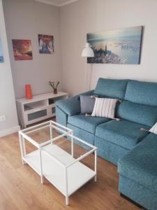 马拉加Apartamento Teatinos Málaga的客厅配有蓝色的沙发和茶几