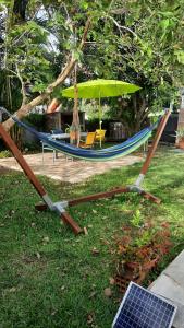 Ducosvilla do brazil的吊床配有遮阳伞和桌椅