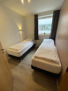 阿克雷里Saga Apartments Akureyri的小型客房 - 带2张床和窗户