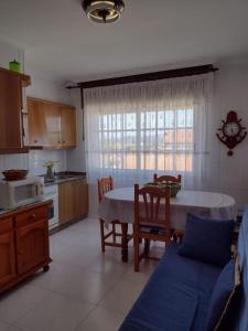 格罗韦Apartamento en San Vicente de O Grove的带桌椅的厨房、带桌子的厨房和厨房。