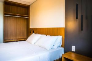 萨利诺波利斯Salinas Premium Resort的客房内的一张带白色枕头的床