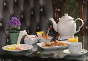 圣地亚哥Hotel Casa Zañartu的餐桌上放有盘子和茶壶