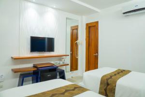 长滩岛The Paragon Boracay Suites的酒店客房设有两张床和一台平面电视。