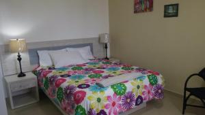苏莎亚Fully Equipped New 2br Apt–dt–2mins To The Beach的一间卧室配有一张带五颜六色花毯的床