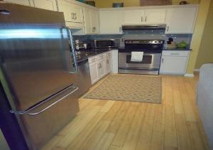 亚特兰大The Samone's的厨房配有不锈钢冰箱和木地板