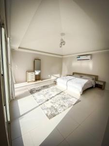 拉斯阿尔卡麦Palm Escape Farmhouse - By Seven Elements的一间白色卧室,配有床和地毯