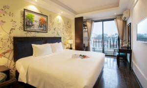 河内Golden Legend Boutique Hotel的酒店客房设有一张大床和一个阳台。
