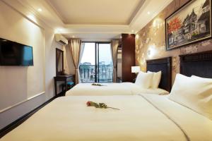 河内Golden Legend Boutique Hotel的酒店客房设有两张床和电视。