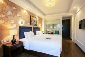 河内Golden Legend Boutique Hotel的一间大卧室,配有一张白色的大床和一张桌子