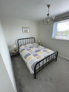 邓巴顿Dumbarton With A View的一间卧室配有一张带 ⁇ 子毯子的床