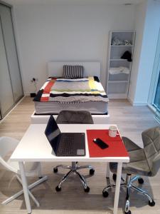 克罗伊登23 floor studio for work 1Gb WiFi的一张睡在白色书桌上的床,上面有笔记本电脑