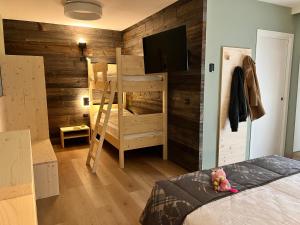 费拉迪普利米罗佩尔拉家庭旅馆的一间卧室设有木墙和一张双层床