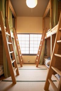大阪ゲストハウス君彩家 kimidoriya的客房设有双层床和大窗户。