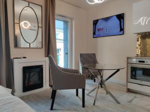 罗兹Piotrkowska.eu Apartament Romantica的客厅设有壁炉、桌子和椅子