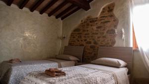卡纳拉Il Casale di Fiore的一间卧室设有两张床和石墙