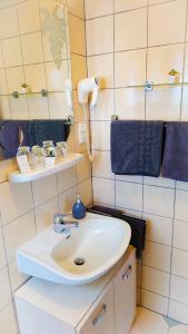 赫尔-格伦茨豪森Hotel Garni Zur Traube的浴室设有白色水槽和镜子