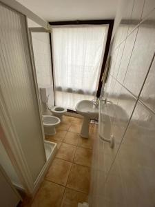 皮亚诺德雷斯内利meschihouse - Piani dei Resinelli 2001的浴室设有2个卫生间、水槽和淋浴。