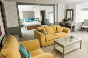 卡莱尔维特拉王冠酒店的一间带黄色家具的客厅和一间卧室