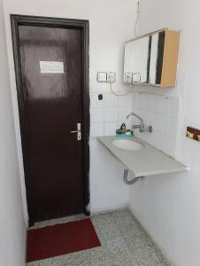 伯利恒B&B at Palestinian home / Beit Sahour的浴室设有黑色的门和水槽。
