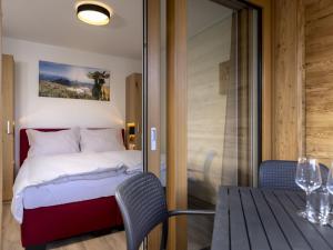 东蒂罗尔地区马特赖Classic holiday home in Matrei in Osttirol with sauna的一间卧室配有一张床、一张桌子和一个玻璃门