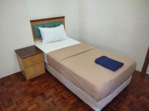 卢穆特Lumut Valley的一间卧室配有一张带蓝色毛巾的床