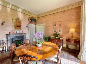 韦尔斯贝丽尔乡村豪宅酒店的一间带木桌和壁炉的用餐室