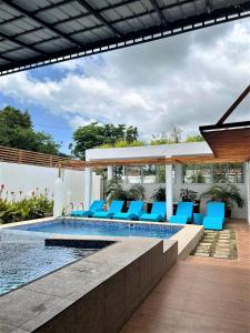 BantayCasa Cecilia Hotel的一座房子旁的游泳池,配有蓝色躺椅