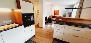 拉德施塔特Apartment Maier的厨房配有白色橱柜和黑色冰箱。