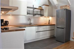 GeschendorfHeuboden的厨房配有白色橱柜和不锈钢冰箱