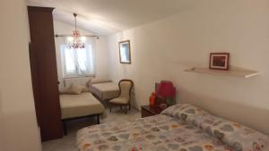 维科德尔加尔加诺Casa Michela的卧室配有床、椅子和窗户。