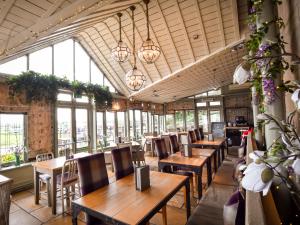 斯特灵The Meadowpark Bar, Kitchen & Rooms的餐厅设有木桌、椅子和窗户。