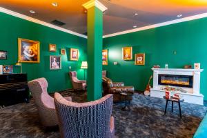 德累斯顿mightyTwice Hotel Dresden的客厅设有绿色的墙壁、椅子和壁炉