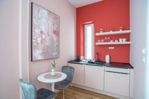 斯普利特Center De Lux Studios “ Zara “的厨房设有红色的墙壁和桌椅