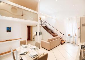 那不勒斯Maison Mele Luxury Apartment的一间带餐桌和楼梯的客厅