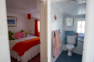 马拉扎恩Krissie's的一间卧室设有一张床、一个卫生间和一个水槽