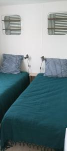 加斯泰"Mar e sou" 412 Camping La Réserve SIBLU的一间卧室配有两张带绿毛毯和枕头的床