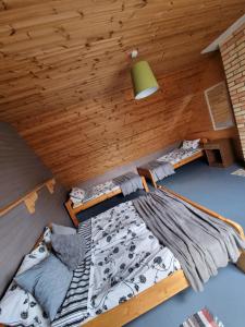 尤卡尔内Brīvdienu māja Rozes的配有木天花板的客房设有两张床。