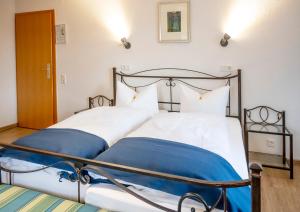 UedemHotel Haus Nachtigall - B&B的一间卧室配有两张带蓝白色床单的床