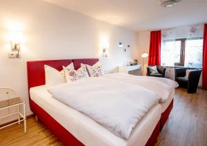 UedemHotel Haus Nachtigall - B&B的一间卧室配有一张白色大床和红色床头板