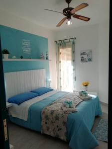 雷阿尔蒙特Maré - Scala dei Turchi的一间卧室配有一张带蓝色床单的床和吊扇。