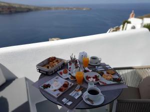 伊亚马瑞森窑洞及别墅酒店的阳台上的早餐桌,包括食物和饮料