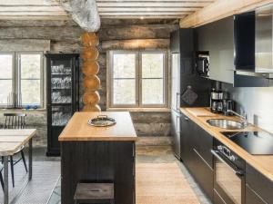锡尔卡Holiday Home Villa toprakka b by Interhome的厨房配有黑色橱柜和木制天花板