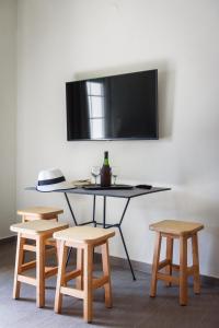 萨索斯Studios Drakontis的一张桌子、四把椅子和墙上的电视