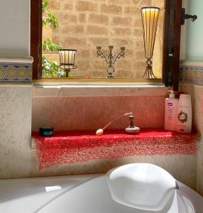 焦维纳佐Palazzo Morola XIV century的浴室配有盥洗盆、镜子和浴缸