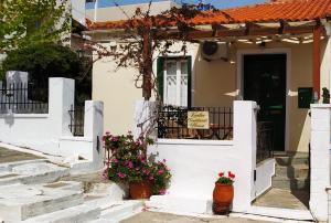 安德罗斯Kontos-Traditional house in Andros beach的前面有鲜花的白色房子