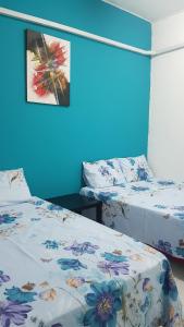怡保12-15 Pax Ssue Silibin Ipoh Guest House-Homestay的蓝色墙壁客房的两张床