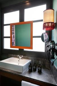 巴塞罗那chic&basic Habana Hoose的浴室水槽和窗户旁的镜子